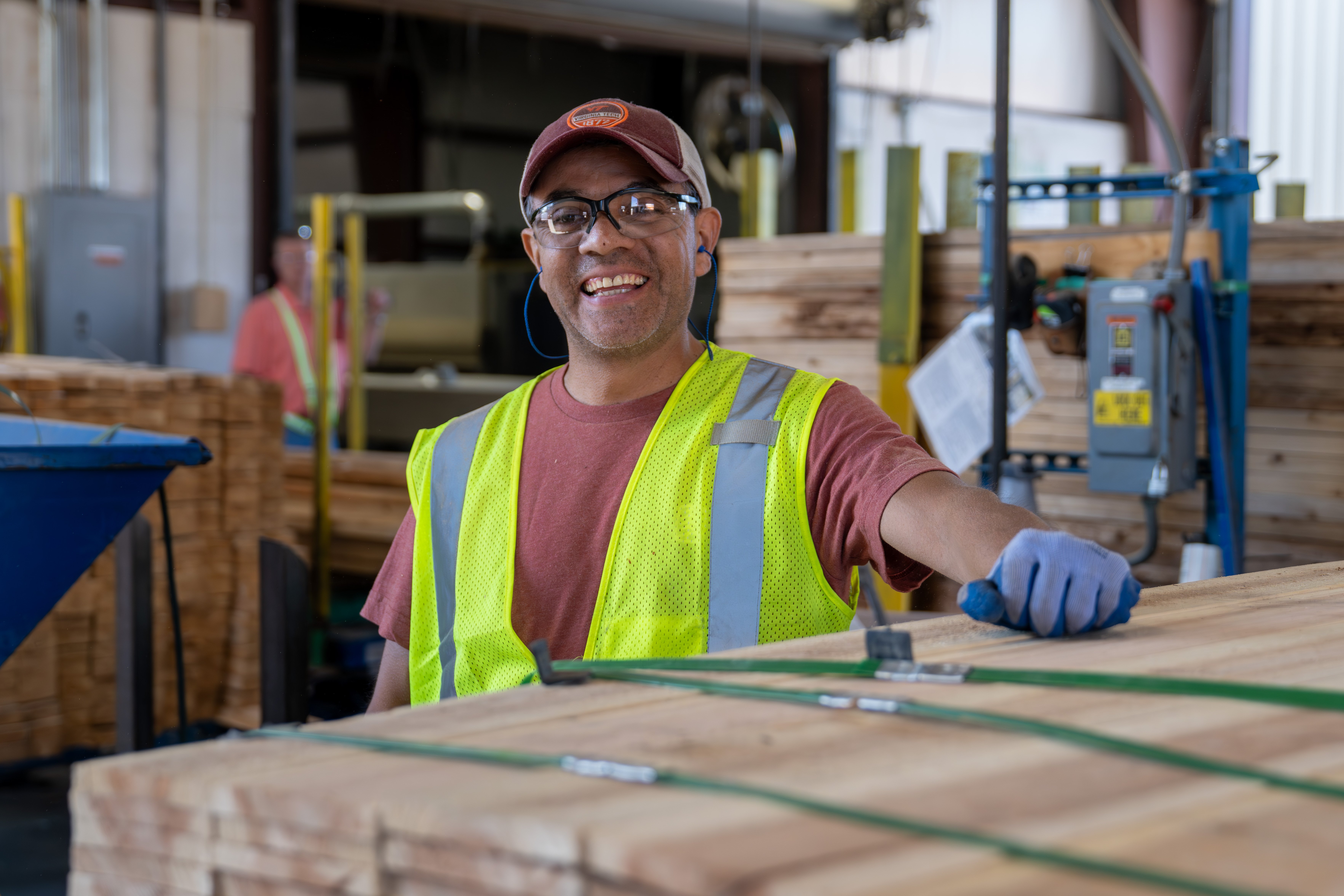 Smiling worker with safety glasses and vest
